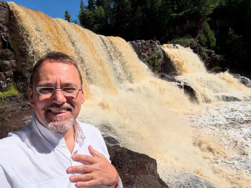 A. Michael Crook beside a Himalayan waterfall